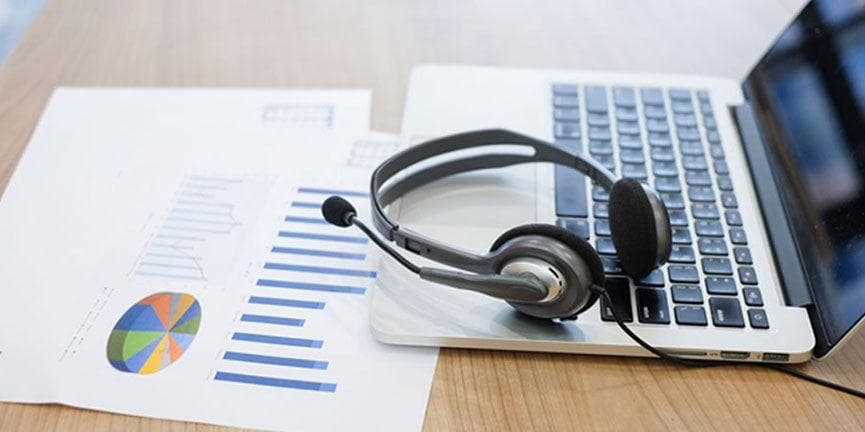 Zang recently introduced a new tool that will enable businesses to create smart communication apps and workflow by simply 'dragging' and 'dropping' functionalities within the design tool. laptop computer and voice headset with analytics and statistics papers