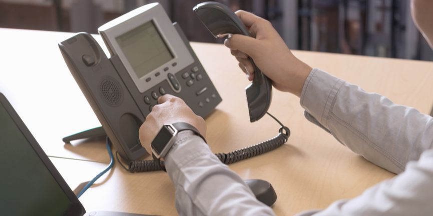 businessman dialing on ip desk phone