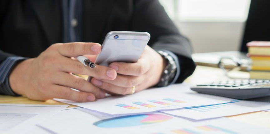 TCN enhances its contact center platform with a new text messaging feature, the AgentSMS. businessman at desk on smartphone sending sms message