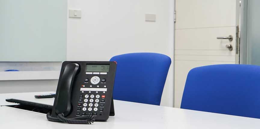 conference calling phone on desk in meeting room