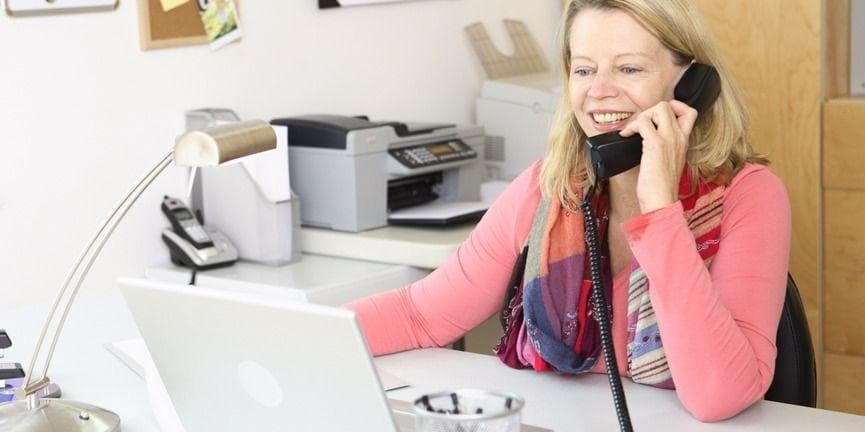 businesswoman in home office answering the phone