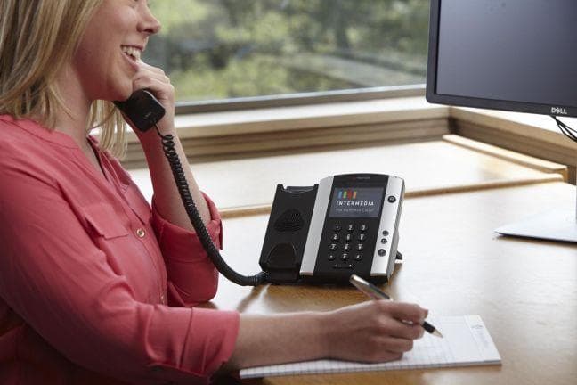 employee using Intermedia desk phone