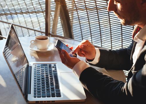 businessman using smartphone with laptop