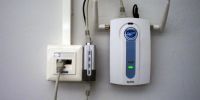 This Ethernet connection includes power over Ethernet (gray cable looping below), and a PoE splitter provides a separate data cable (gray, looping above) and power cable (black, also looping above) for a wireless access point. power over ethernet example