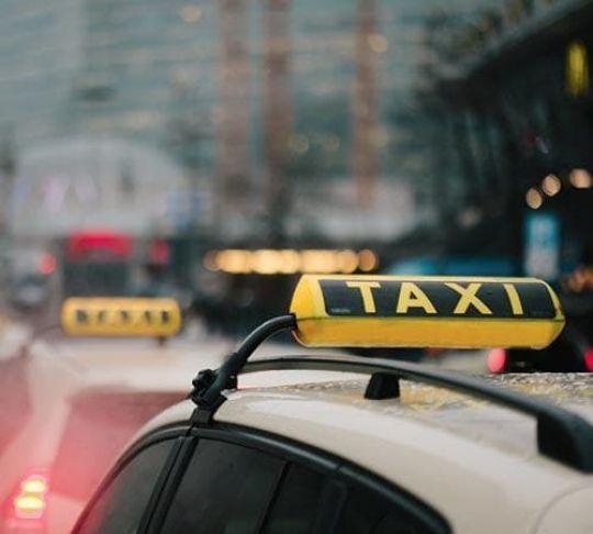 row of taxi cabs waiting for passengers