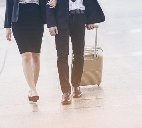 woman and man walking with suitcase