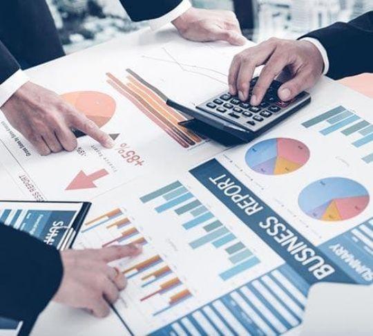accountants analyzing graphs with calculator