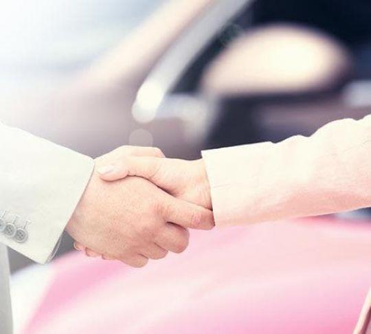 At a car dealership, a VoIP phone system can increase communications and enhance customer service. handshake after car sale