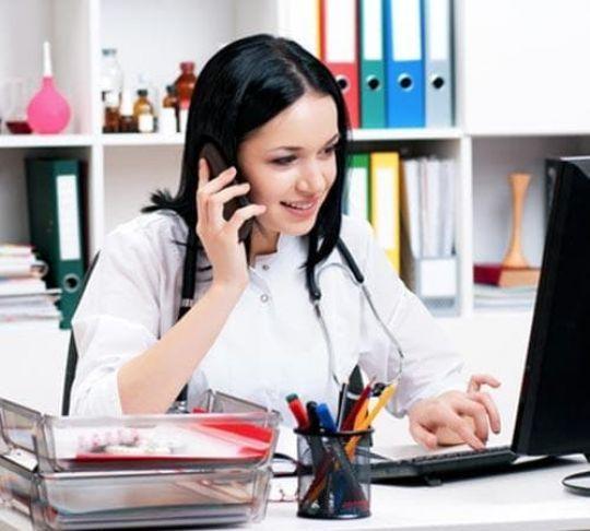 woman doctor using desk phone in medical office