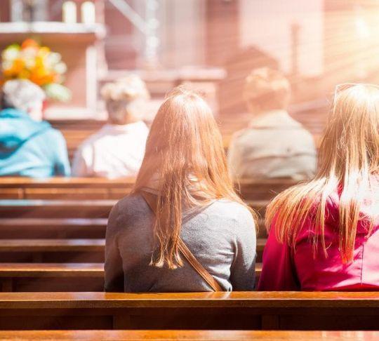people kneeling in church pews