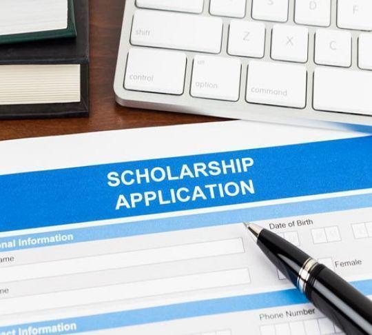 scholarship application form with pen and keyboard