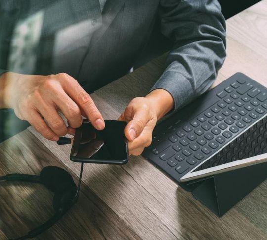 employee using mobile phone and laptop for voip