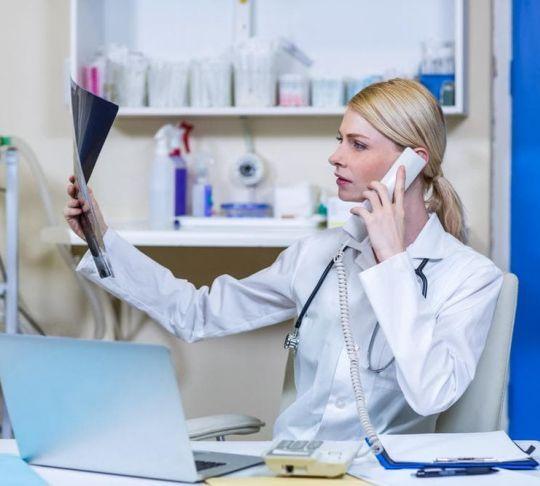 woman veterinarian with x-rays on phone